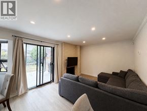 Richmond apartment for rent - A living room with a grey couch and a fireplace.