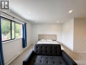 Richmond apartment for rent - A bedroom with a large bed and a window with blue curtains.
