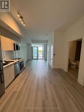 Toronto (Clairlea-Birchmount) condo for rent - A spacious kitchen with wooden flooring and a view of the backyard.