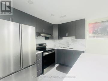 Whitby (Rolling Acres) apartment for rent - A modern kitchen with a stainless steel refrigerator and black cabinets.