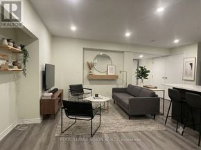 Whitby (Rolling Acres) apartment for rent - A living room with a grey couch, a coffee table, and a TV.