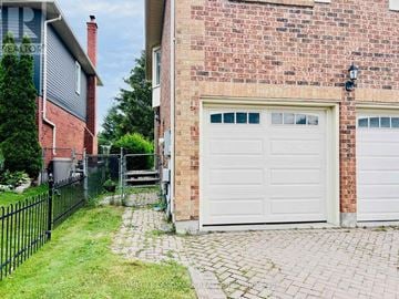 Newmarket (Glenway Estates) apartment for rent - A brick house with a white garage door and a black fence.