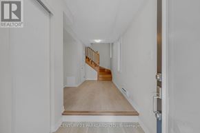 Pickering (Village East) townhouse for rent - A hallway with a wooden staircase and white walls.