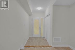 Pickering (Village East) townhouse for rent - A hallway with a door on the right and a brokerage logo on the wall.