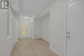 Pickering (Village East) townhouse for rent - A white hallway with wood flooring and a door on the right.
