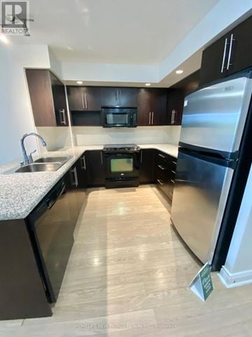 Markham (Unionville) condo for rent - A kitchen with black cabinets and a stainless steel refrigerator.