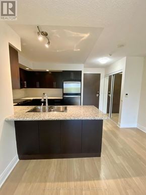 Markham (Unionville) condo for rent - A kitchen with a granite countertop and wooden cabinets.