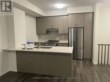 Vaughan (Vaughan Corporate Centre) townhouse for rent - A kitchen with a refrigerator, sink, and cabinets.