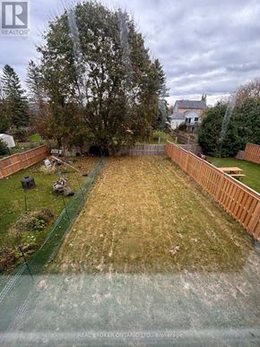 Grey Highlands townhouse for rent - A backyard with a wooden fence and a green lawn.