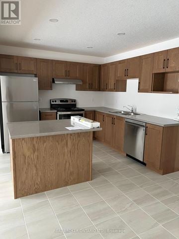 Grey Highlands townhouse for rent - A kitchen with wooden cabinets and a stainless steel refrigerator.