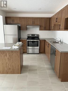 Grey Highlands townhouse for rent - A kitchen with wooden cabinets and a white refrigerator.