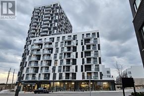 Oakville (Jm Joshua Meadows) condo for rent - A modern building with a glass entrance and a sign that reads "Century 21 Kennedy".