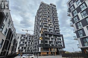 Oakville (Jm Joshua Meadows) condo for rent - A tall residential building stands in front of other buildings.