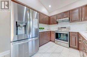 Pickering (Amberlea) apartment for rent - A kitchen with a stainless steel refrigerator and wooden cabinets.