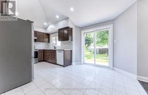 Pickering (Amberlea) apartment for rent - A spacious kitchen with a refrigerator, cabinets, and a dishwasher.