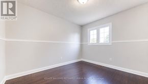 Pickering (Amberlea) apartment for rent - A room with a window and a wooden floor.