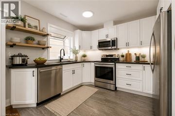 Toronto apartment for rent - A modern kitchen with white cabinets and stainless steel appliances.