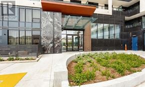 Oakville (Jm Joshua Meadows) condo for rent - The front of a building with a glass door and a sign that says "REALTOR".