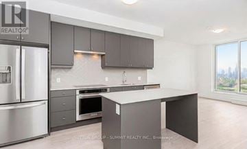 Oakville (Jm Joshua Meadows) condo for rent - A modern kitchen with a stainless steel refrigerator and a large island.