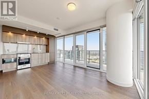 Mississauga (City Centre) condo for rent - A spacious living room with wooden floors and large windows.