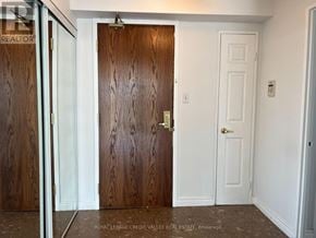 Mississauga (City Centre) condo for rent - A white door is in a hallway with a wooden door on the left.