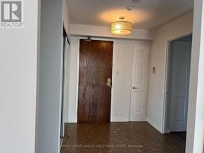 Mississauga (City Centre) condo for rent - A hallway with a wooden door and white walls.