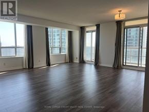 Mississauga (City Centre) condo for rent - A spacious room with wooden flooring and large windows.