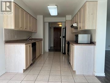 Mississauga (City Centre) condo for rent - A kitchen with wooden cabinets and a white refrigerator.