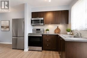 London East (East A) townhouse for rent - A kitchen with a refrigerator, oven, microwave, and sink.