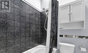 London East (East A) townhouse for rent - A bathroom with a black tiled shower area and white fixtures.