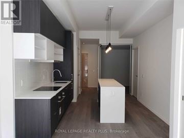 Toronto (Mount Pleasant West) condo for rent - A modern kitchen with dark wood cabinets and white countertops.