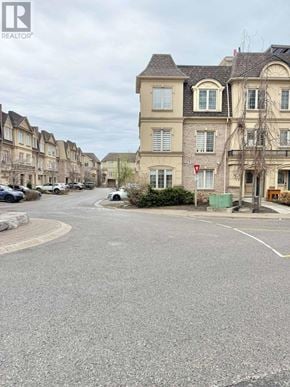 Pickering (Bay Ridges) townhouse for rent - A street view of a residential area with houses on both sides and a car parked on the left.