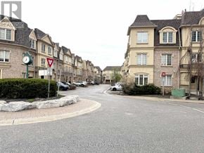 Pickering (Bay Ridges) townhouse for rent - A street view of a residential area with houses on both sides and a clock on a pole in the foreground.