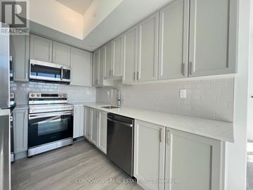 Pickering (Bay Ridges) condo for rent - A kitchen with white cabinets and a stainless steel oven.