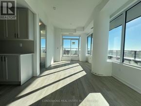 Pickering (Bay Ridges) condo for rent - A spacious room with wooden floors and large windows.