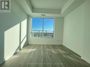 Pickering (Bay Ridges) condo for rent - A room with a large window and wooden flooring.