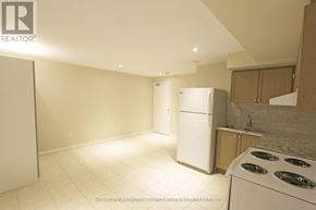 Toronto (Dovercourt-Wallace Emerson-Junction) apartment for rent - A kitchen with a white fridge and a white stove.
