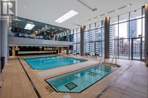 Toronto (Waterfront Communities) condo for rent - A large indoor swimming pool with a glass wall on one side.
