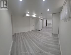 Toronto (West Hill) apartment for rent - A spacious room with wooden flooring and white walls.