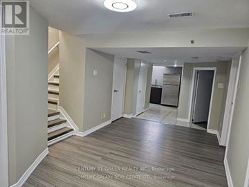 Mississauga (Erin Mills) apartment for rent - A spacious room with a staircase on the left and a kitchen area on the right.