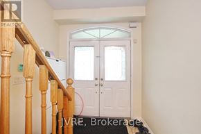 Mississauga (Churchill Meadows) apartment for rent - A hallway with a wooden staircase leading to a white door.