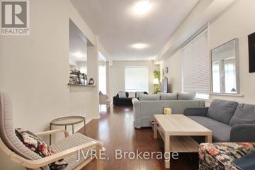 Mississauga (Churchill Meadows) apartment for rent - A living room with a grey couch and a white chair.