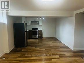 Toronto (Downsview-Roding-Cfb) apartment for rent - A kitchen area with a black fridge, microwave, and oven.