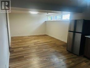 Toronto (Downsview-Roding-Cfb) apartment for rent - A room with wooden flooring and a stainless steel refrigerator.