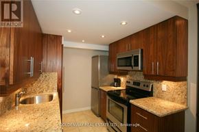 Toronto (Bay Street Corridor) condo for rent - A kitchen with wooden cabinets and granite countertops.