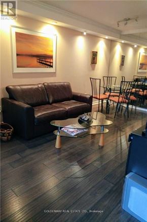 Toronto (Bay Street Corridor) condo for rent - A living room with a brown leather couch and a coffee table.