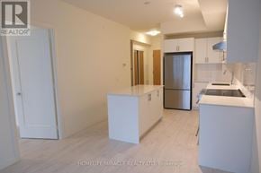 Vaughan (Vellore Village) condo for rent - A white kitchen with a refrigerator, sink, and cabinets.