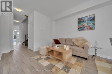 Barrie townhouse for rent - A living room with a couch, coffee table, and a painting on the wall.