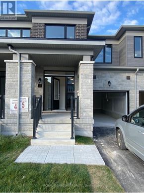 Barrie townhouse for rent - A modern house with a grey car parked in front.