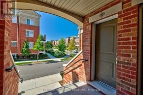 Oakville (Ro River Oaks) townhouse for rent - A view from a doorway looking out to a street with a sign that says "REALTOR".
